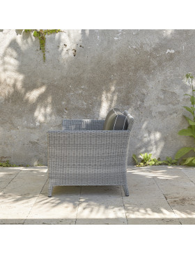 Two-seater rattan couch with UV resistant cushions side view in French grey on a southern French terrace