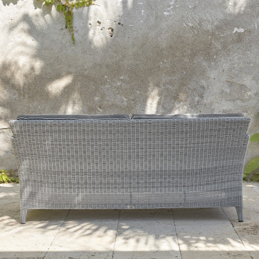 Two-seater rattan couch with UV resistant cushions back view in French grey on a southern French terrace