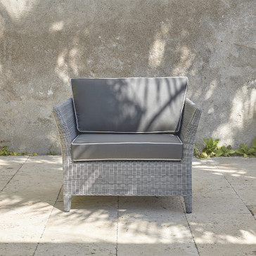 Durable and elegant rattan garden armchair in French grey with UV resistant cushions on a southern French terrace