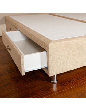 Divan bed base with drawer open upholstered in an oatmeal furniture fabric pictured on a wooden floor